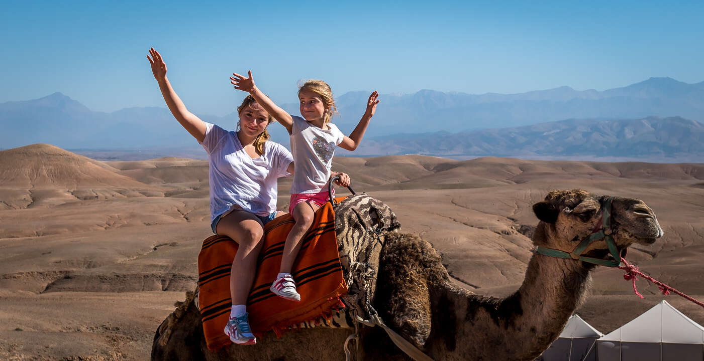 Family enjoying camel ride in Sahara Desert slider